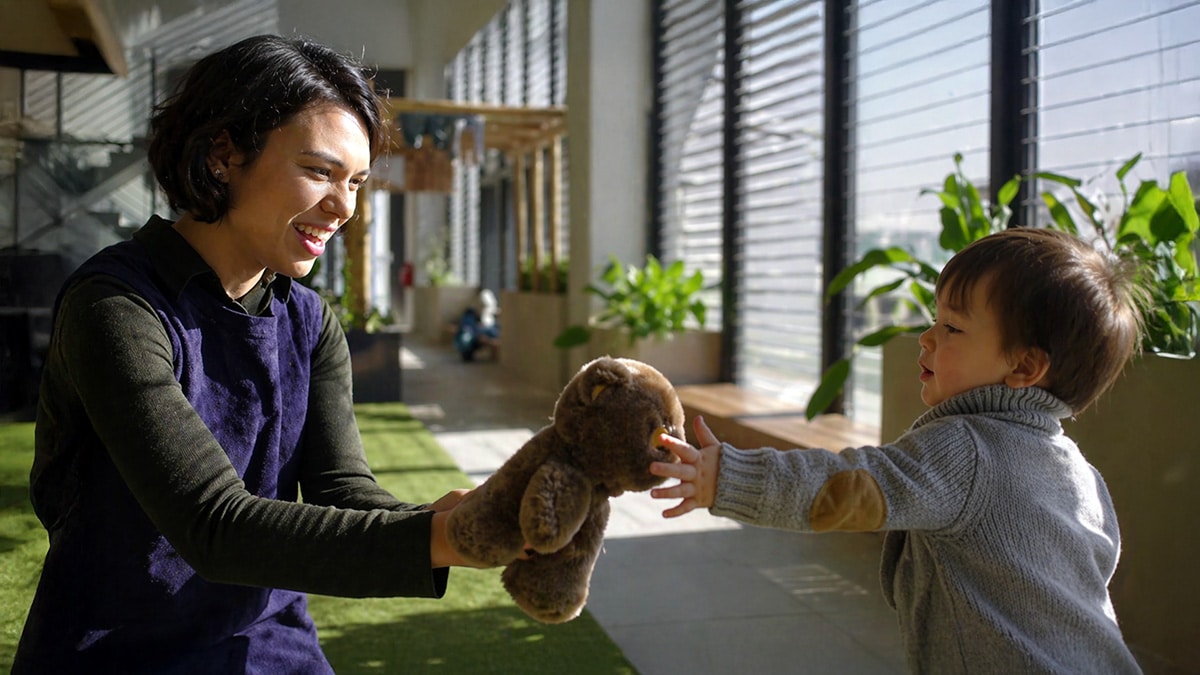 Parent interacting warmly with a young child holding a soft toy in a bright home, illustrating supportive and low-pressure encouragement