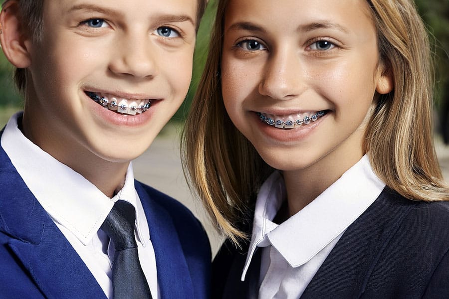 Boy and girl with braces in school uniforms