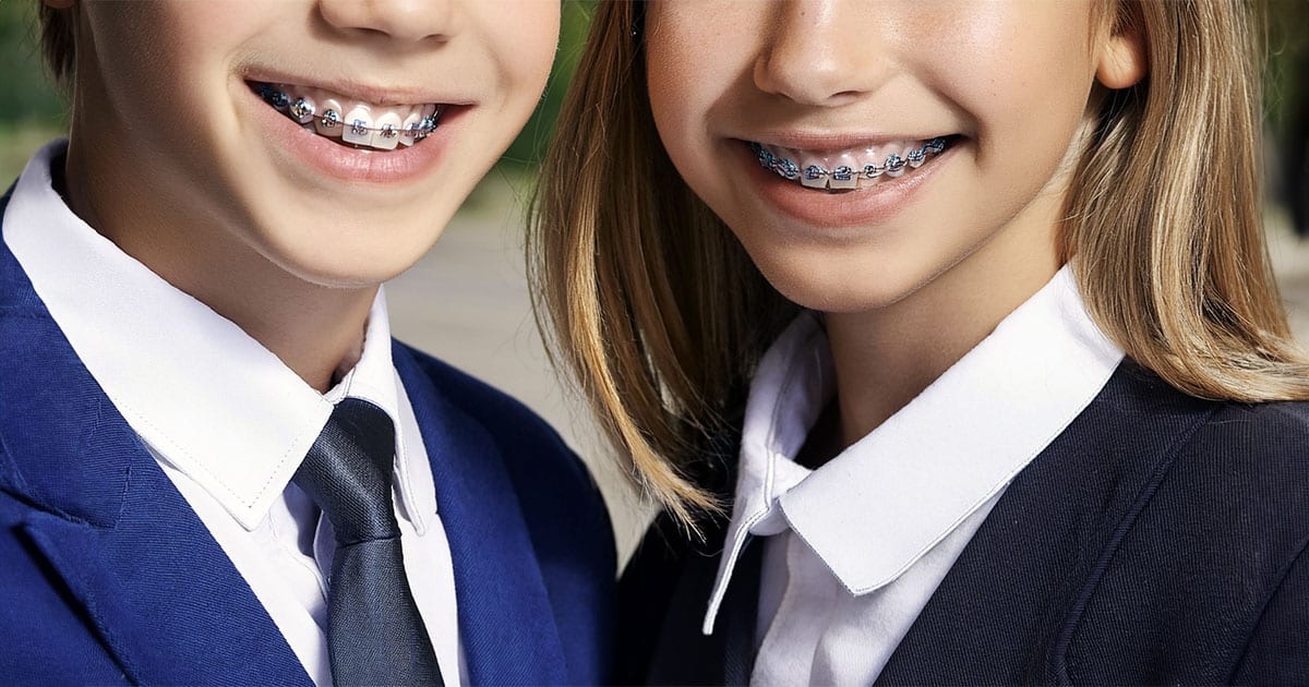 Boy and girl with braces in school uniforms