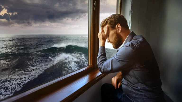 Despondent man indoors overlooking stormy seas