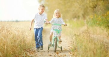 Happy children travelling along bike lane.