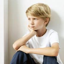 Forlorn boy sitting in corner