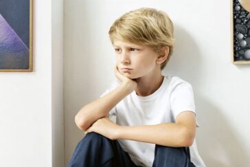 Forlorn boy sitting in corner