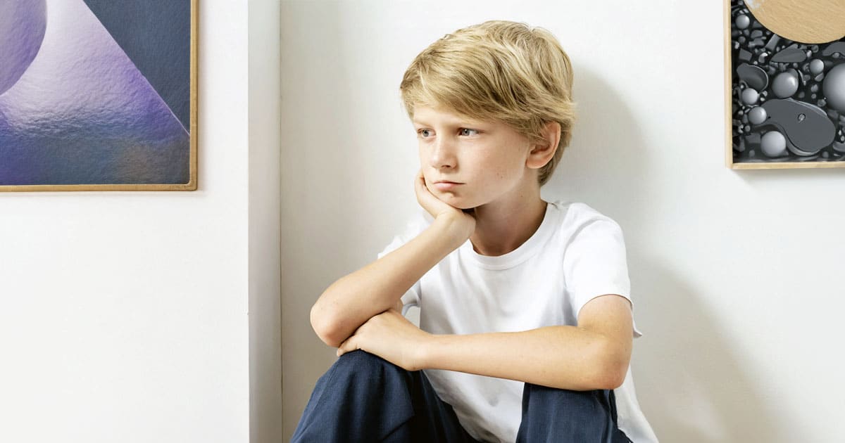 Forlorn boy sitting in corner