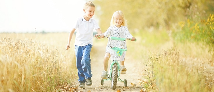 Happy children travelling along bike lane.