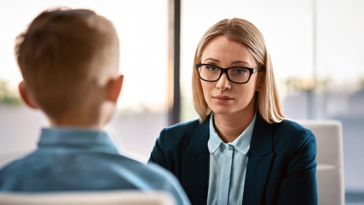 Psychologist or counsellor interviewing boy