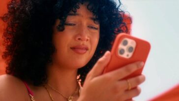 Woman on sunbed looking at her phone with interest